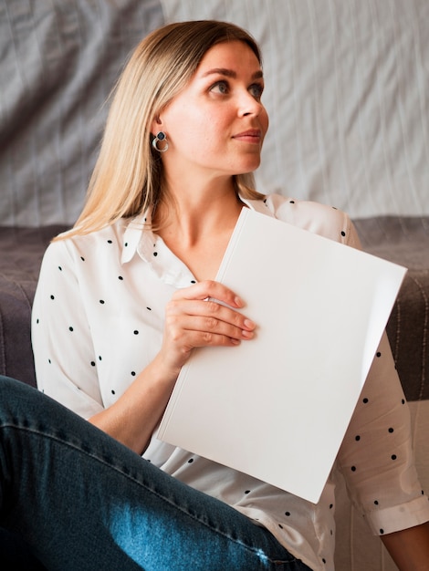 Free Photo woman holding a mock-up magazine