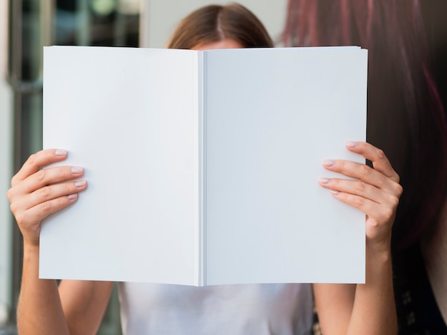 Free photo woman holding a mock-up magazine