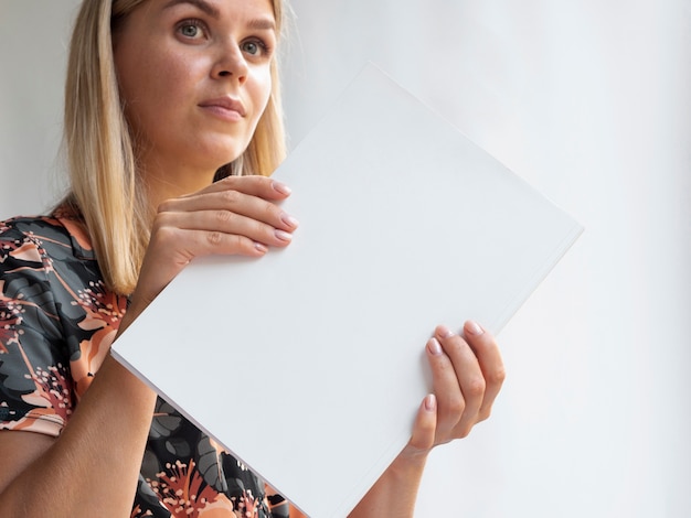 Free Photo woman holding a mock-up magazine