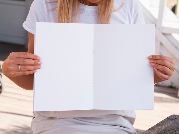 Free photo woman holding a mock-up magazine