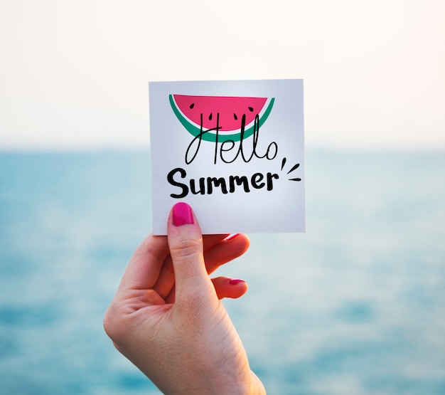 Free photo woman holding note with summer graphic at the beach