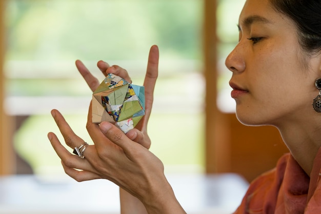 Free photo woman holding an origami object