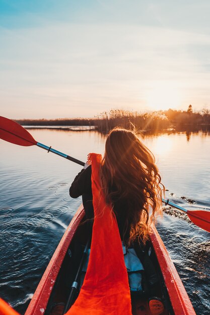 Woman holding paddle in a kayak on the river