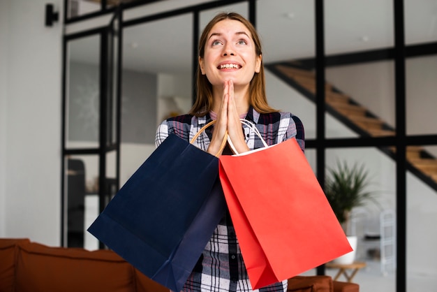 Woman holding paper bags and praying