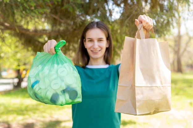 Free photo woman holding paper and plastic bags