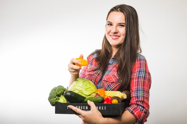 Woman holding pepper and pallet with vegetables