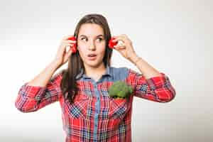 Free photo woman holding peppers near ears