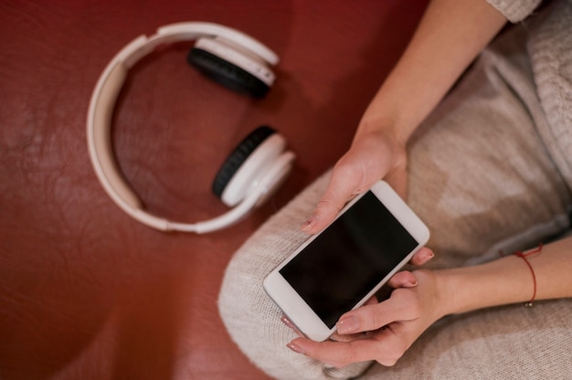 Woman holding phone near headphones