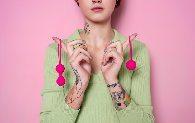 Free photo woman holding pink sex toys