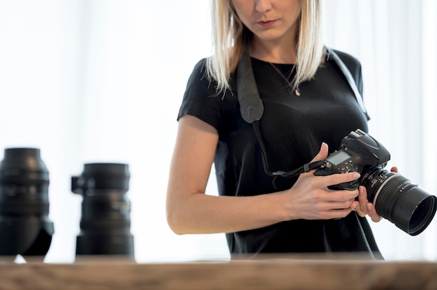 Free Photo woman holding a professional camera and lens