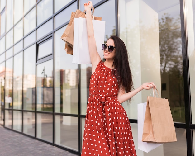 Woman holding shopping bags and looking away