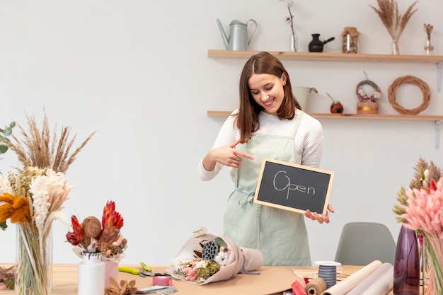 Woman holding a sign with opening soon