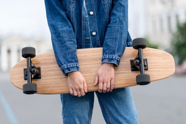 Woman holding a skateboard front view