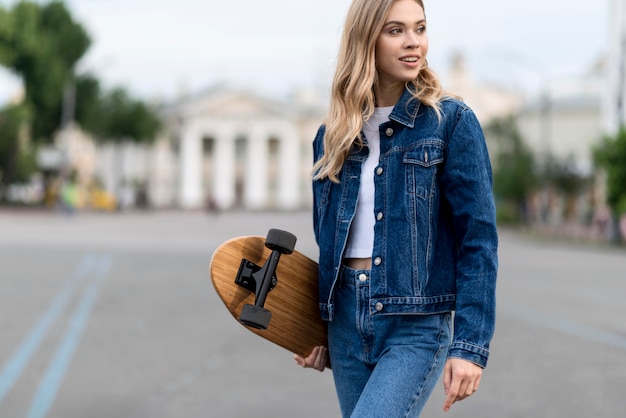 Free Photo woman holding a skateboard