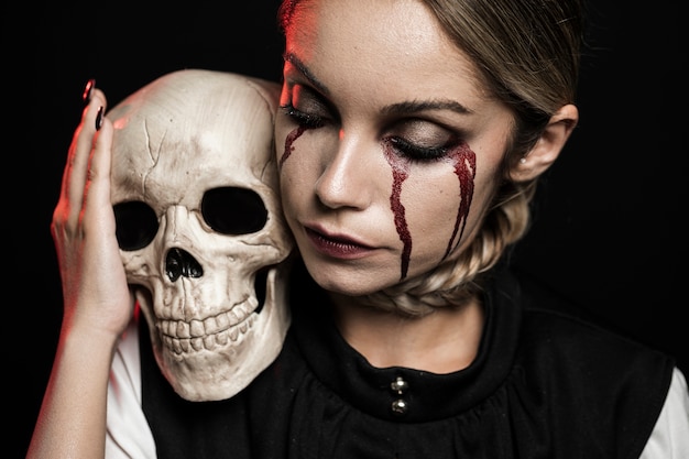 Free photo woman holding skull on shoulder