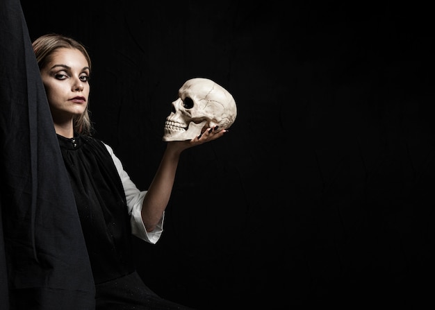 Free Photo woman holding skull with copy space