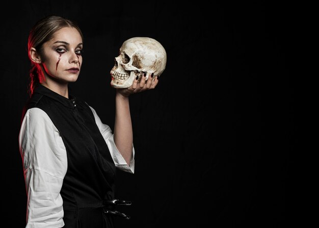 Woman holding skull with copy space