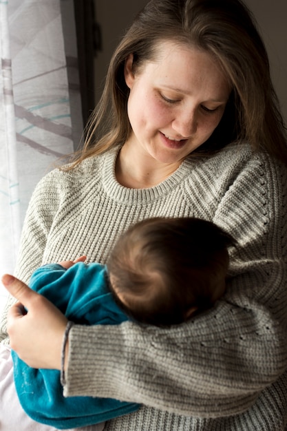 Free Photo woman holding sleeping baby in arms