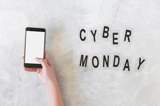 Free photo woman holding smartphone near cyber monday inscription