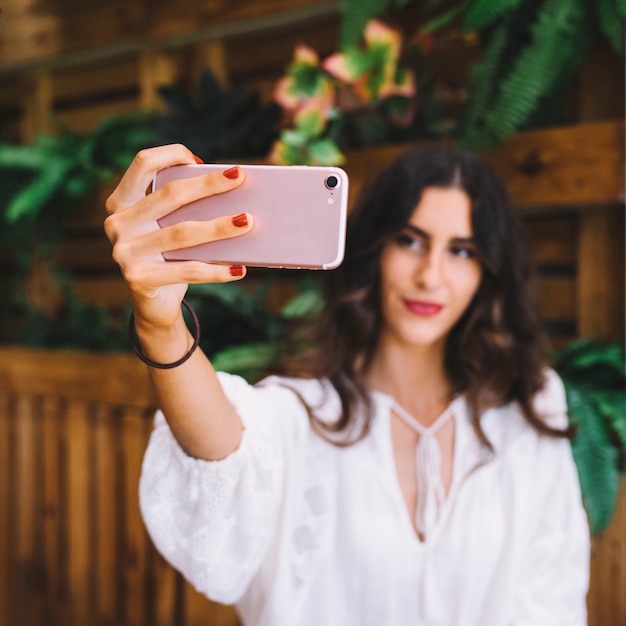 Woman holding smartphone to take selfie