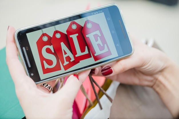 Free Photo woman holding smartphone with inscription on screen