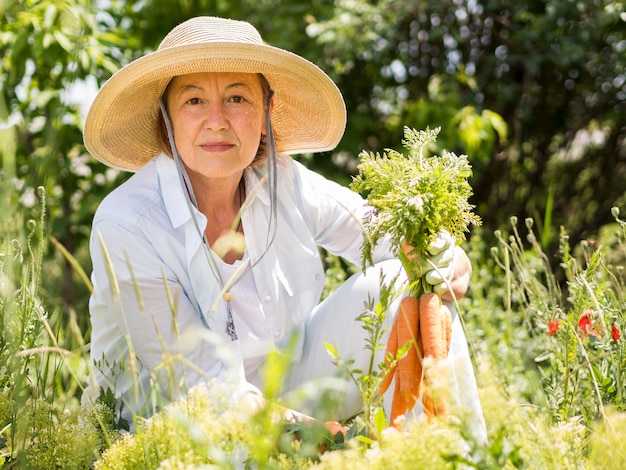 Woman holding some fresh carrots in her hand