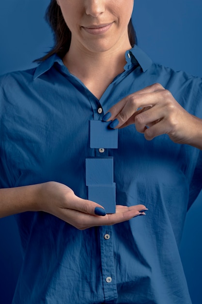 Woman holding stacked classic blue color cubes