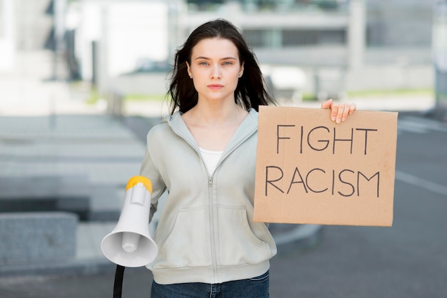 Free photo woman holding stop racism sign and megaphone