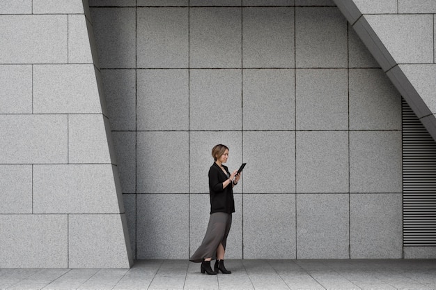 Free photo woman holding tablet full shot