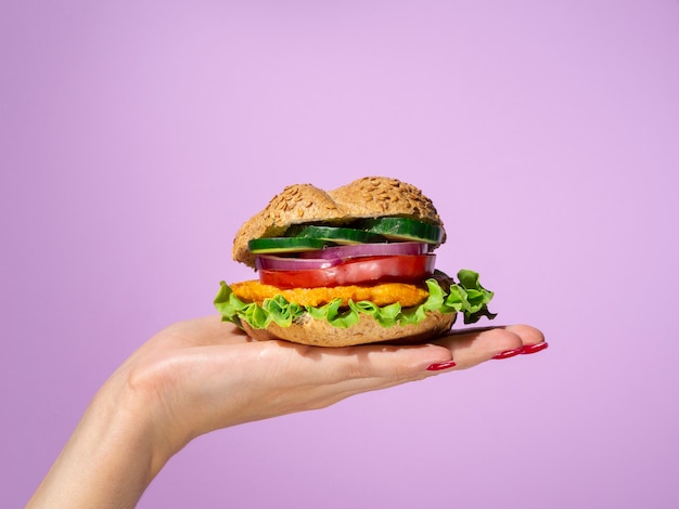 Free photo woman holding a tasty burger in her palm