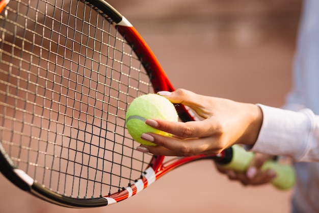 Woman holding a tennis ball and racket