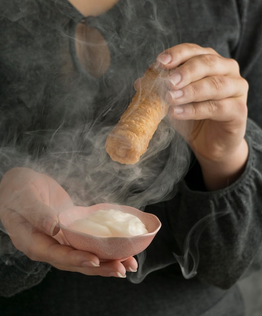 Free photo woman holding traditional tequenos dish