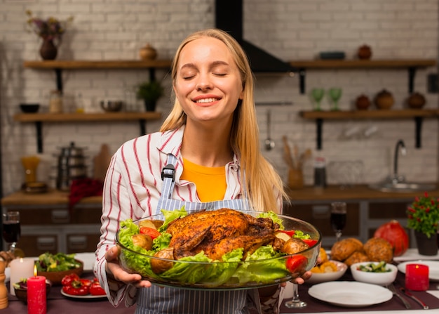 Free photo woman holding a turkey with salad dressing