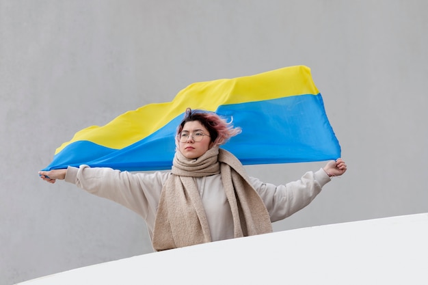 Free Photo woman holding ukrainian flag medium shot