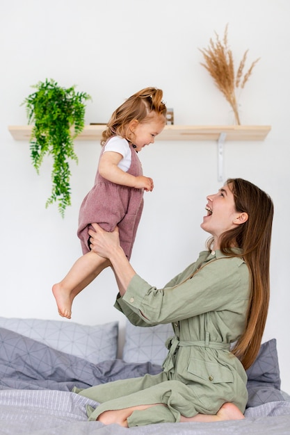 Woman holding up girl side view