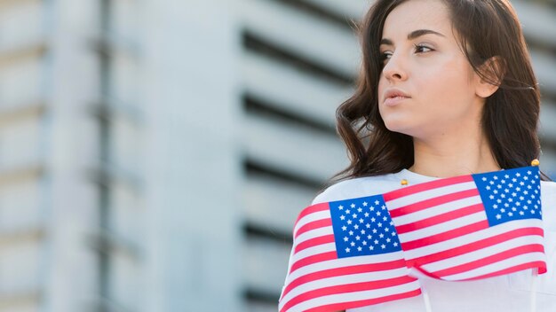 Woman holding usa flags looking away