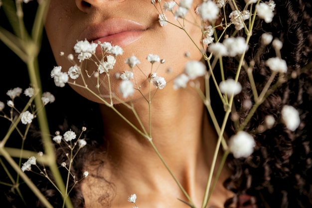 Free photo woman holding white flowers at face