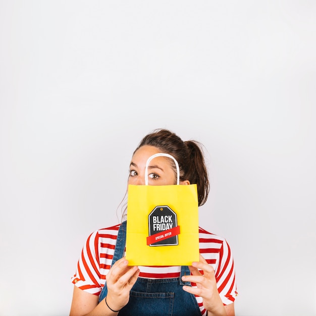 Free Photo woman holding yellow bag with black friday label