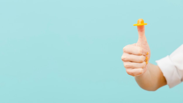 Woman holding a yellow condom on her finger with copy space