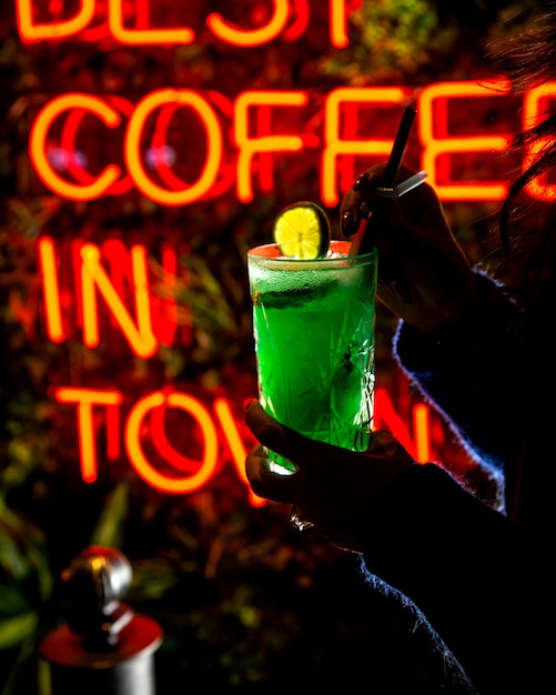 Free Photo woman holds green refreshing beverage