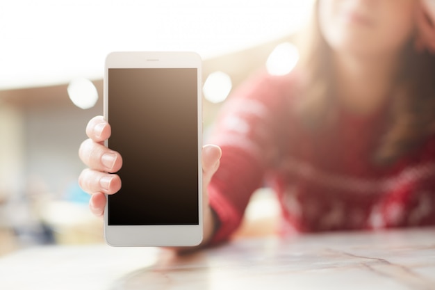 Woman holds modern white smart phone