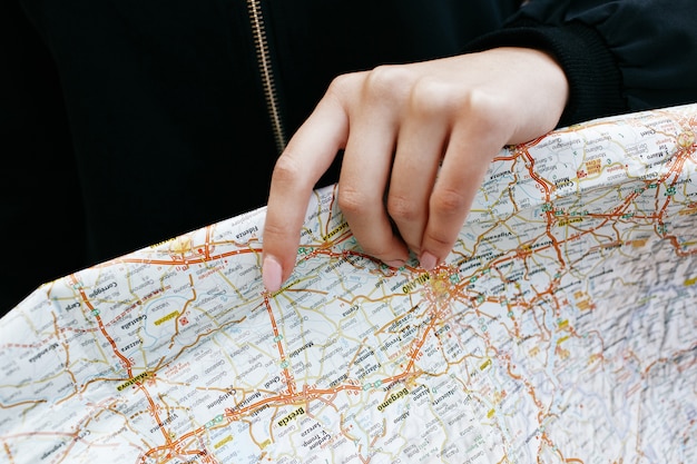 Free photo woman holds touristic map in her arm