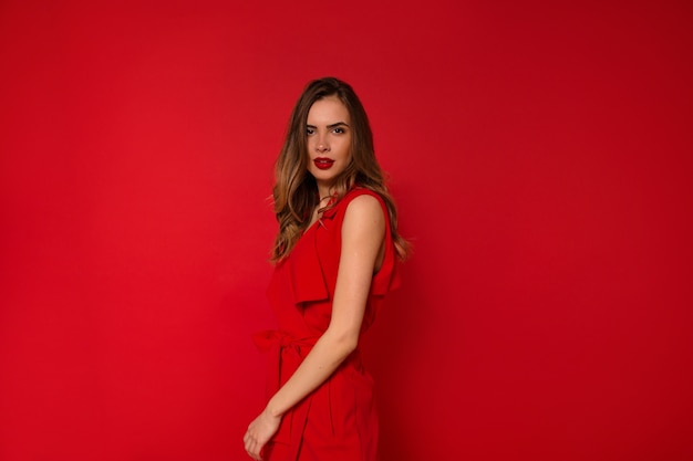 Woman in holiday red dress with red lips posing