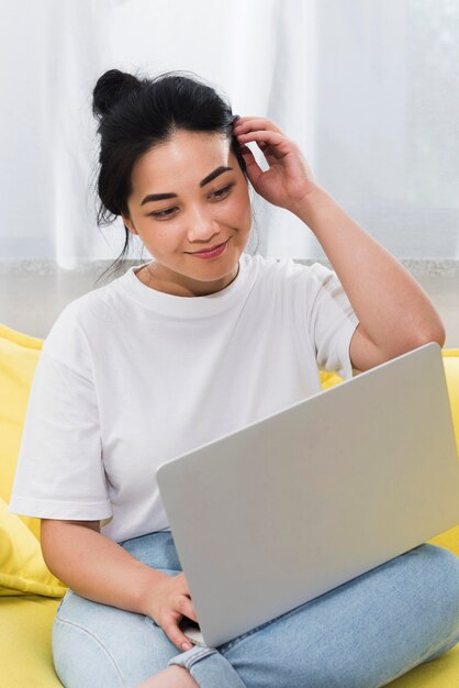 Woman at home on couch with laptop