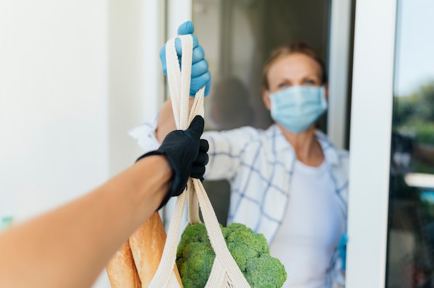 Woman at home picking up her groceries in self-isolation