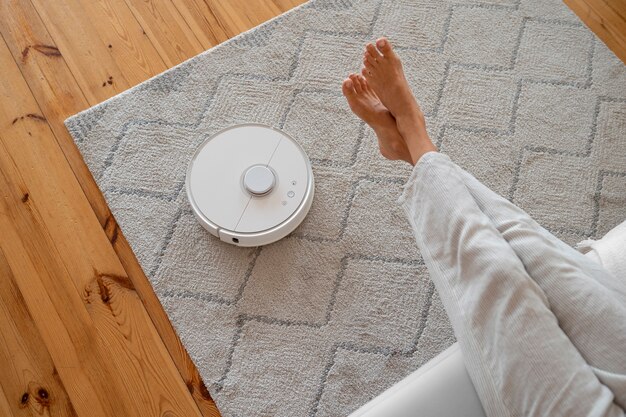 Woman at home with robotic wireless vacuum cleaner