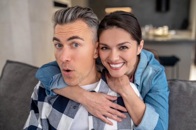 Free photo woman hugging cheerful man looking at camera