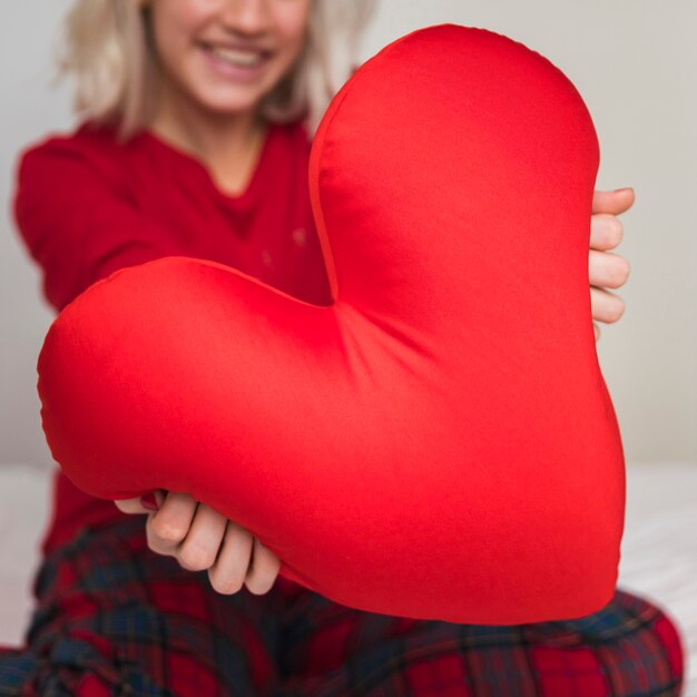 Woman hugging heart pillow on valentines day