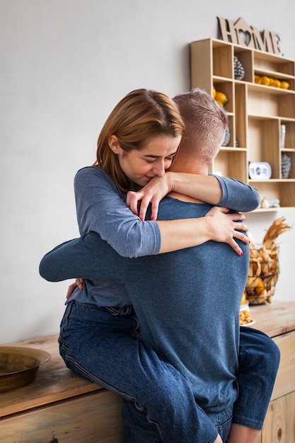 Woman hugging her husband in the kitchen