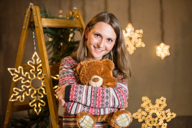 Free Photo woman hugging teddy at christmas